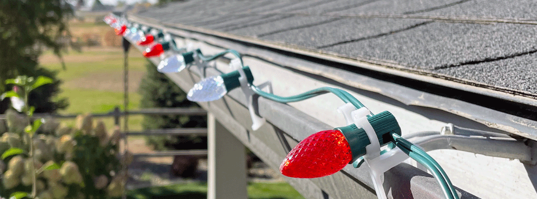 Closeup of red and white Christmas lights along roofline